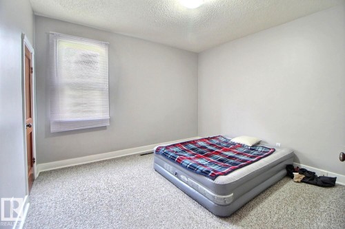 Window with horizontal blinds, light gray wall paint, and light-colored carpeting - 11626 87 Street Nw, Edmonton, AB - Indoor Photo Showing Bedroom