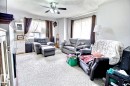 Living area featuring carpet flooring and multiple windows with curtain rods - 11626 87 Street, Edmonton, AB  - Indoor Photo Showing Living Room 