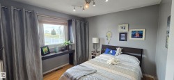 Bedroom featuring wood-finish flooring, a track lighting fixture, and a built-in window ledge - 
