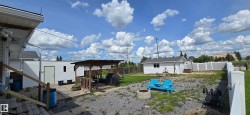 Expansive outdoor space featuring a covered gazebo, a detached shed, and a privacy fence - 