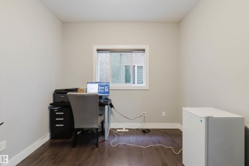 Neutral-toned room featuring a single window, dark wood-finish flooring, and white baseboards - 17030 62 Street, Edmonton, AB - Indoor Photo Showing Office