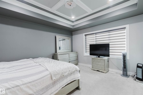 Room featuring a tray ceiling with recessed lighting, light gray carpeting, and a window with horizontal blinds - 17030 62 Street, Edmonton, AB - Indoor Photo Showing Bedroom