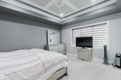 Room featuring a tray ceiling with recessed lighting, light gray carpeting, and a window with horizontal blinds - 