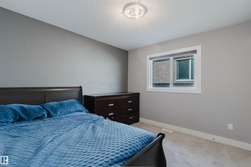 Carpeted room featuring a white-trimmed window, light grey walls, and a ceiling-mounted light fixture - 17030 62 Street, Edmonton, AB - Indoor Photo Showing Bedroom