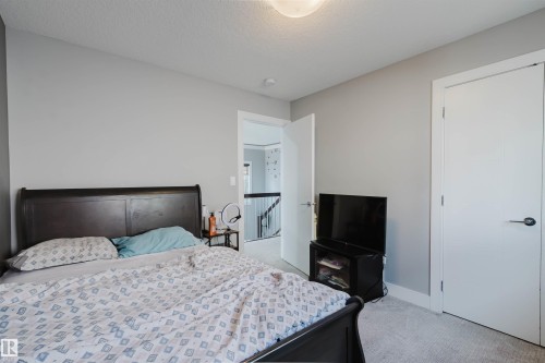 Light gray walls complement the neutral carpeting in this room, featuring a white paneled door with contemporary black hardware - 17030 62 Street, Edmonton, AB - Indoor Photo Showing Bedroom