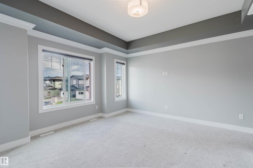 Spacious room featuring light gray walls, white trim, and a tray ceiling with a contrasting dark gray accent - 17030 62 Street, Edmonton, AB - Indoor Photo Showing Other Room