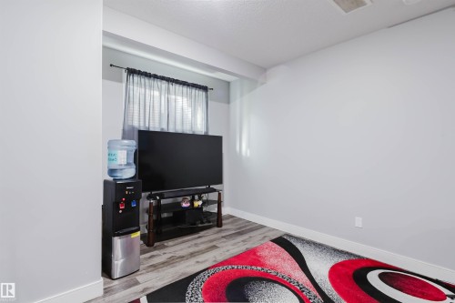 Bright interior space featuring light gray walls, wood-finish flooring, and white baseboards - 17030 62 Street, Edmonton, AB - Indoor