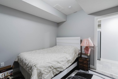 Bedroom space featuring light gray walls, white trim, a ceiling-mounted smoke detector, and a doorway opening to a tiled area - 17030 62 Street, Edmonton, AB - Indoor Photo Showing Bedroom