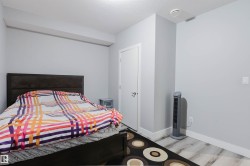 Spacious room featuring light gray walls and wood-finish flooring - 