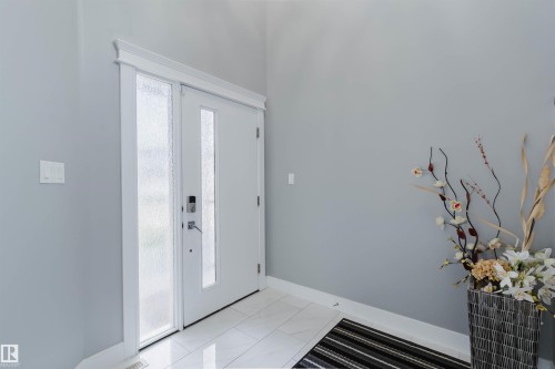 Entryway featuring a white door with a frosted glass panel and a bright white tile floor - 17030 62 Street, Edmonton, AB - Indoor Photo Showing Other Room