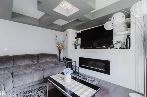 Coffered ceiling with recessed lighting and a central chandelier - 17030 62 Street, Edmonton, AB - Indoor Photo Showing Living Room With Fireplace