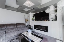 Coffered ceiling with recessed lighting and a central chandelier - 