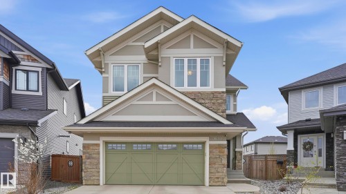 Contemporary two-story residence featuring light green siding, stone accents, and a prominent front-facing gable - 2620 Adam Crest, Edmonton, AB - Outdoor