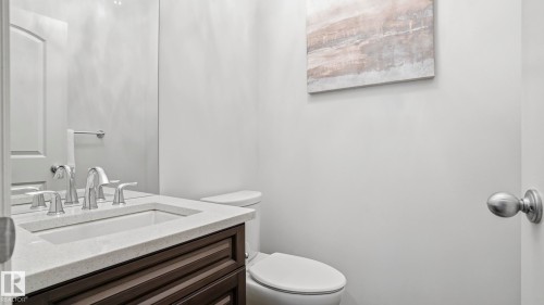 White walls featuring a vanity with a light-toned countertop, an integrated rectangular sink, and a chrome faucet - 2620 Adam Crest, Edmonton, AB - Indoor Photo Showing Bathroom