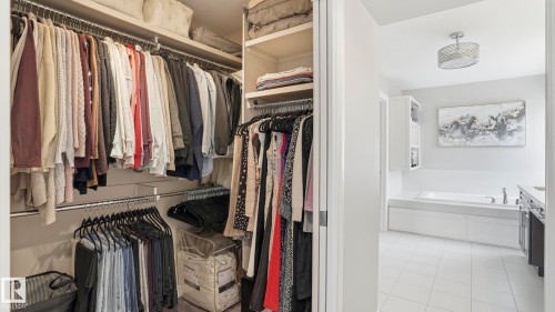 Walk-in closet featuring multiple hanging rods and integrated shelving - 2620 Adam Crest, Edmonton, AB - Indoor With Storage