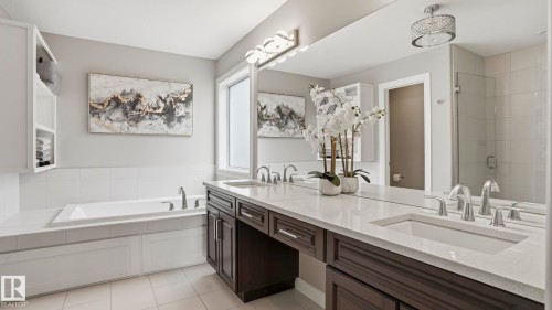 Dual vanity with integrated sinks and dark wood cabinetry, featuring a quartz countertop and chrome fixtures - 2620 Adam Crest, Edmonton, AB - Indoor Photo Showing Bathroom