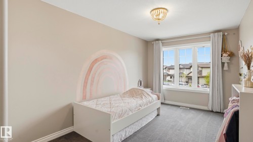 Room featuring a large triple-pane window, neutral wall paint, ceiling-mounted light fixture, and grey carpet flooring - 2620 Adam Crest, Edmonton, AB - Indoor Photo Showing Bedroom