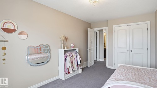 Neutral-toned wall paint throughout, plush grey carpeting, white double-door closet, and overhead flush-mount lighting fixture - 2620 Adam Crest, Edmonton, AB - Indoor Photo Showing Bedroom