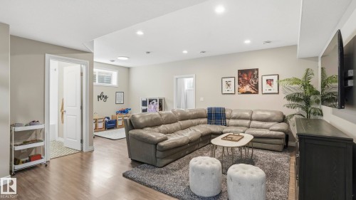 Finished lower level featuring recessed lighting, wood-finish flooring, light neutral paint, and a window for natural light - 2620 Adam Crest, Edmonton, AB - Indoor Photo Showing Living Room