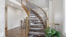 Curved staircase featuring carpeted treads, wood handrails, and wrought iron balusters - 2620 Adam Crest, Edmonton, AB  - Indoor Photo Showing Other Room 