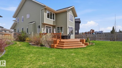 Expansive green lawn featuring a multi-level wood deck with broad stairs - 2620 Adam Crest, Edmonton, AB - Outdoor With Deck Patio Veranda