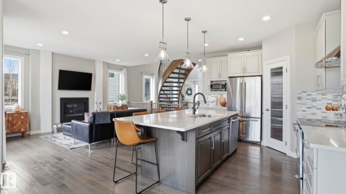 Open-concept living space featuring wood-finish flooring, recessed lighting, and a kitchen island with seating - 2620 Adam Crest, Edmonton, AB - Indoor Photo Showing Kitchen With Stainless Steel Kitchen With Upgraded Kitchen