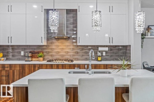 Modern kitchen featuring a large island with an undermount sink and chrome faucet - 219 Cranberry Bend, Fort Saskatchewan, AB - Indoor Photo Showing Kitchen With Double Sink With Upgraded Kitchen
