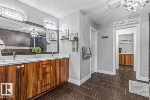 Dual-sink vanity with wood-finish cabinetry and white countertops - 219 Cranberry Bend, Fort Saskatchewan, AB - Indoor Photo Showing Bathroom
