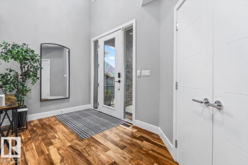 Entryway featuring a front door with sidelights, wood-finish flooring, and high ceilings - 219 Cranberry Bend, Fort Saskatchewan, AB - Indoor Photo Showing Other Room