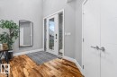 Entryway featuring a front door with sidelights, wood-finish flooring, and high ceilings - 219 Cranberry Bend, Fort Saskatchewan, AB  - Indoor Photo Showing Other Room 