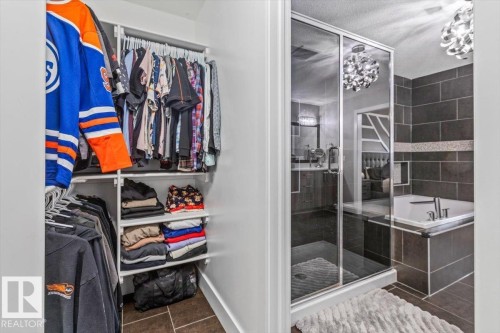 Walk-in closet with adjustable shelving and hanging rods - 219 Cranberry Bend, Fort Saskatchewan, AB - Indoor With Storage