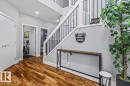 Foyer featuring rich wood-finish flooring, white trim, recessed lighting, and a contemporary staircase with black metal balusters - 219 Cranberry Bend, Fort Saskatchewan, AB  - Indoor Photo Showing Other Room 