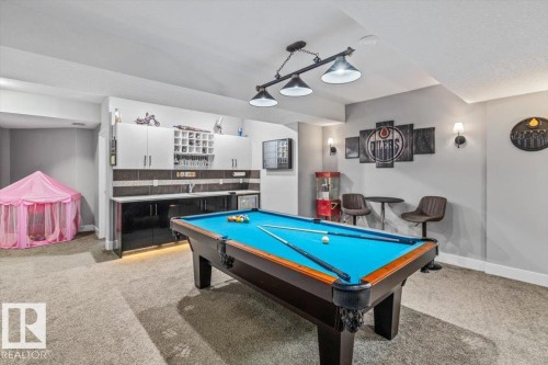 Recreation room featuring a pool table with blue felt, a wet bar with white upper cabinetry and black lower cabinetry, and recessed lighting - 219 Cranberry Bend, Fort Saskatchewan, AB - Indoor Photo Showing Other Room