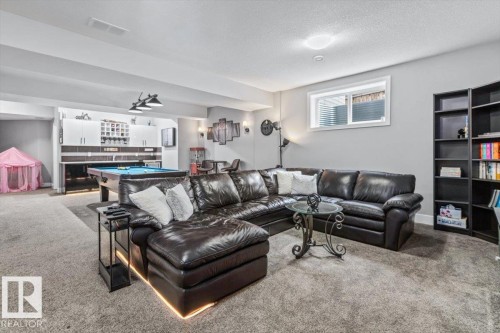 Finished lower level featuring recessed lighting, a built-in wet bar, a window, and plush carpeting - 219 Cranberry Bend, Fort Saskatchewan, AB - Indoor Photo Showing Living Room