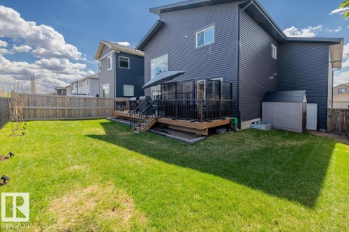 Spacious backyard featuring a wooden privacy fence, a multi-level wooden deck with black railings, and a detached storage shed - 219 Cranberry Bend, Fort Saskatchewan, AB - Outdoor