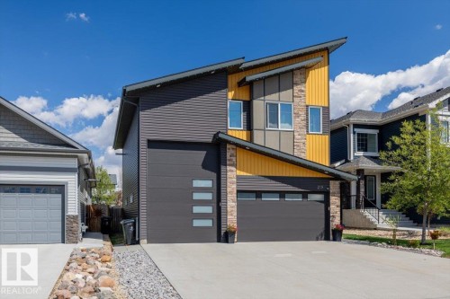 Modern exterior with contrasting yellow and gray siding, stone accents, and an angular roofline - 219 Cranberry Bend, Fort Saskatchewan, AB - Outdoor With Facade