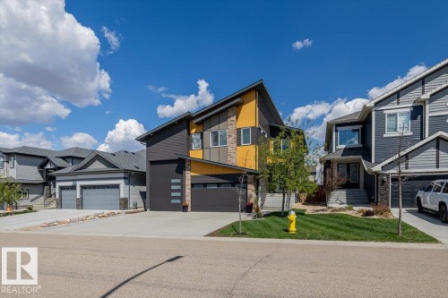 Modern multi-level residence featuring a dark gray and yellow exterior with stone accents - 219 Cranberry Bend, Fort Saskatchewan, AB - Outdoor With Facade