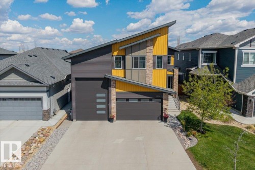Modern architectural home with a striking facade, featuring varied siding in charcoal and yellow tones - 219 Cranberry Bend, Fort Saskatchewan, AB - Outdoor