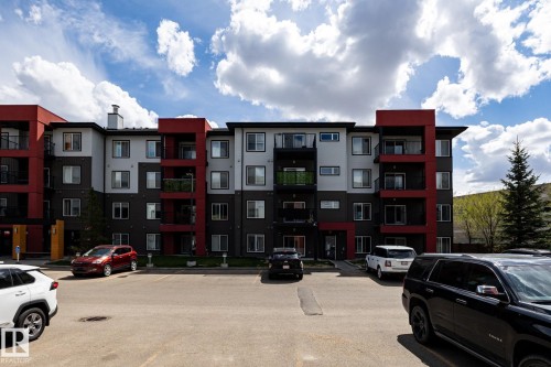 Multi-story residential building featuring a modern facade with red, gray, and white paneling - 131 344 Windermere Road, Edmonton, AB - Outdoor With Facade
