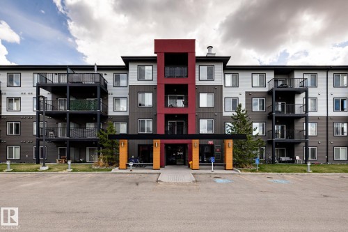 Modern multi-story building featuring a prominent central entrance with a red accent facade - 131 344 Windermere Road, Edmonton, AB - Outdoor With Facade