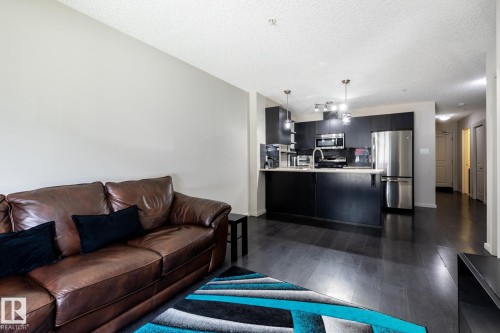 Open-concept living area with dark wood-finish flooring - 131 344 Windermere Road, Edmonton, AB - Indoor