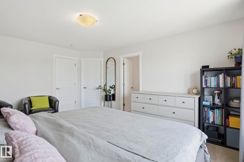 Interior space featuring light-toned walls, a flush-mount ceiling light fixture, and two panel doors with modern hardware - 2116 159 Street, Edmonton, AB - Indoor Photo Showing Bedroom