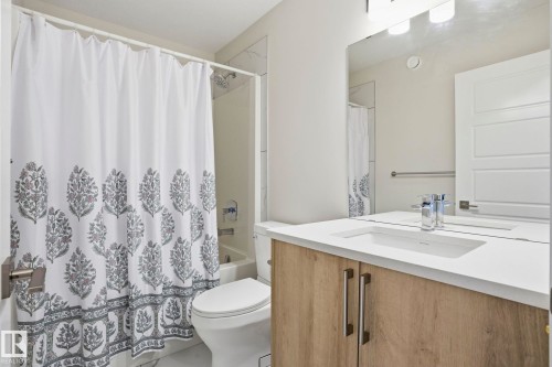 Bathroom featuring a contemporary vanity with a light wood-finish cabinet and a white countertop with an integrated rectangular sink - 2116 159 Street, Edmonton, AB - Indoor Photo Showing Bathroom