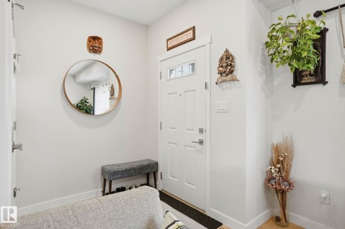 Entryway featuring a white paneled door with glass inserts, light neutral wall paint, and light wood-finish flooring - 2116 159 Street, Edmonton, AB - Indoor Photo Showing Other Room