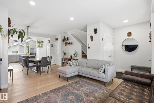 Open-concept living space featuring light wood-finish flooring, recessed lighting, and a contemporary pendant light fixture over the dining area - 2116 159 Street, Edmonton, AB - Indoor Photo Showing Living Room
