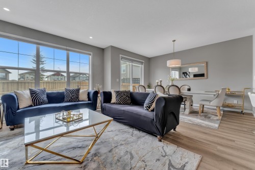 Open concept living area featuring large windows, light gray walls, and light wood flooring - 21853 98A Avenue, Edmonton, AB - Indoor Photo Showing Living Room
