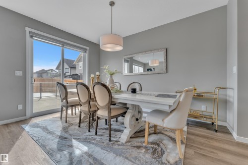 This bright dining area features light wood-style flooring and a sliding glass door providing access to the outdoor deck - 21853 98A Avenue, Edmonton, AB - Indoor Photo Showing Dining Room