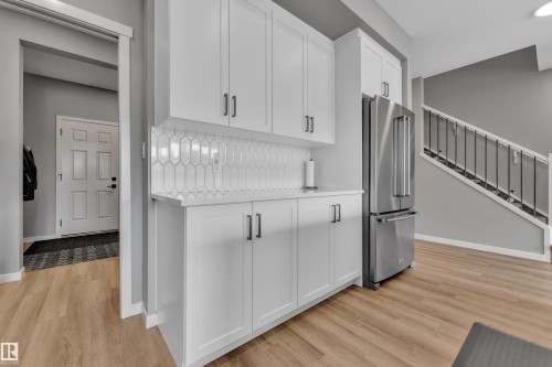 Kitchenette with white cabinetry, a white backsplash, and a stainless steel refrigerator - 21853 98A Avenue, Edmonton, AB - Indoor Photo Showing Kitchen