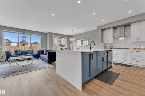 The open concept living area features light-toned flooring, large windows, and recessed lighting - 21853 98A Avenue, Edmonton, AB - Indoor Photo Showing Kitchen With Upgraded Kitchen