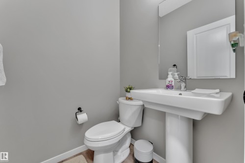 Bathroom featuring a white pedestal sink, a toilet, and a mirror with a white frame - 21853 98A Avenue, Edmonton, AB - Indoor Photo Showing Bathroom